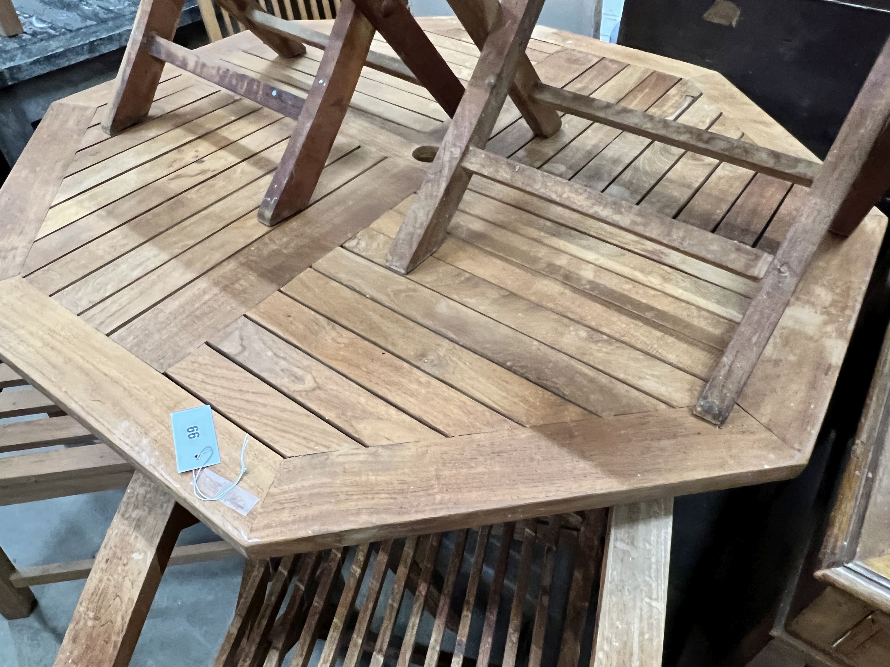 An octagonal teak folding garden table, length 120cm, height 74cm and four folding teak garden chairs, two with arms